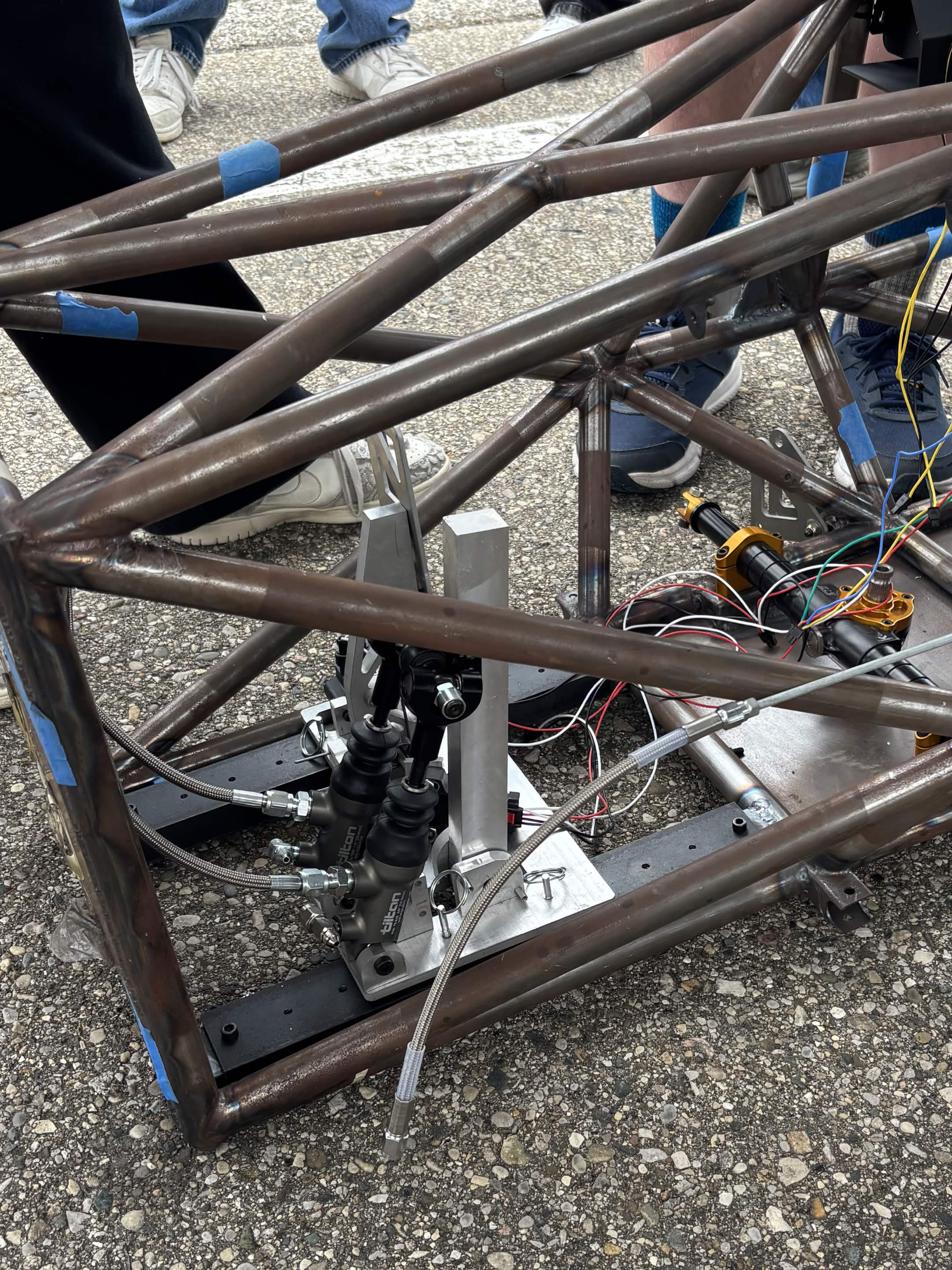Finished pedalbox installed in the chassis — mounted on the driver rails alongside the steering rack and brake lines.