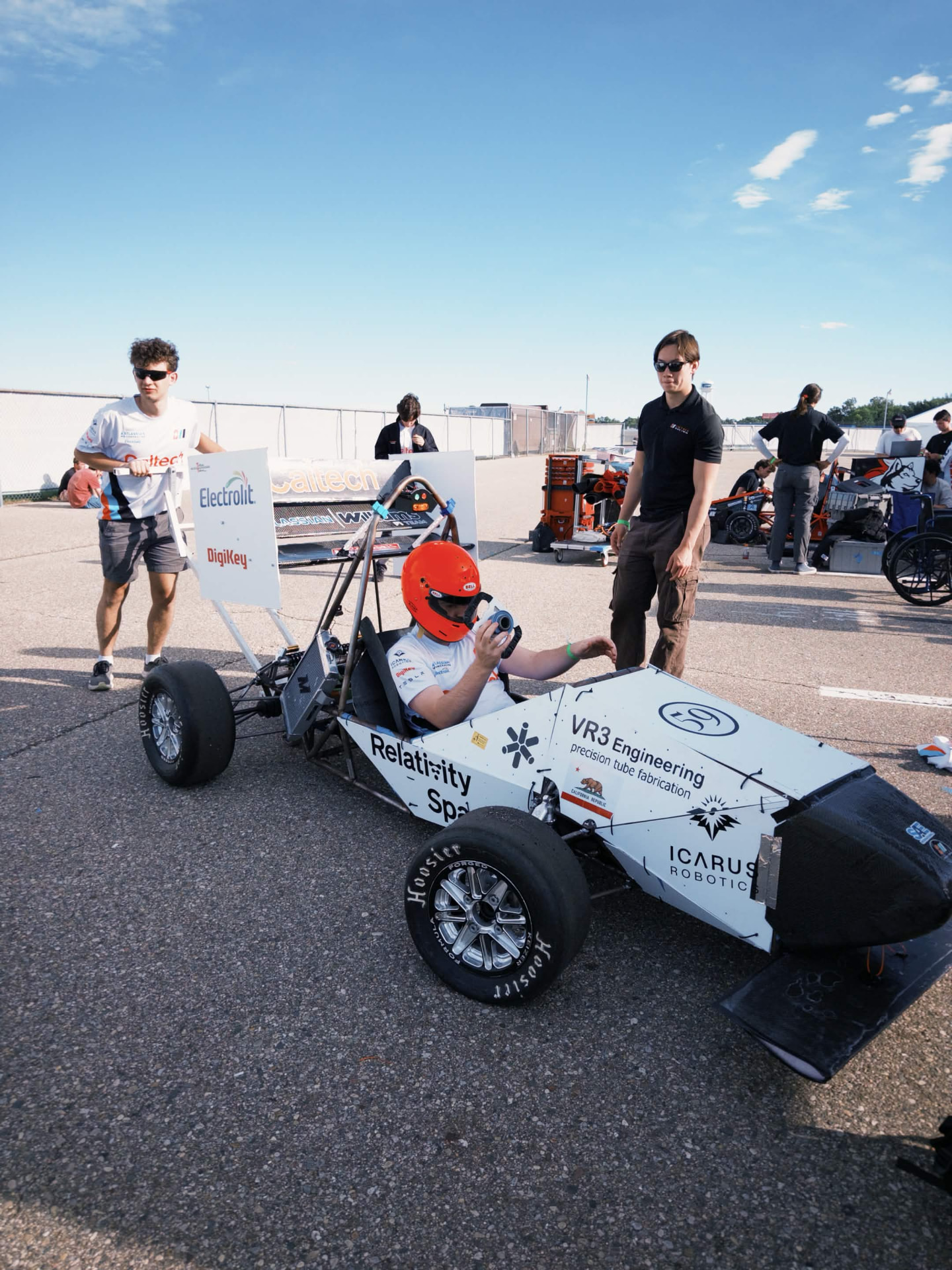 The finished 2026 car at competition — driver seated with the pedalbox and brake system in the car.